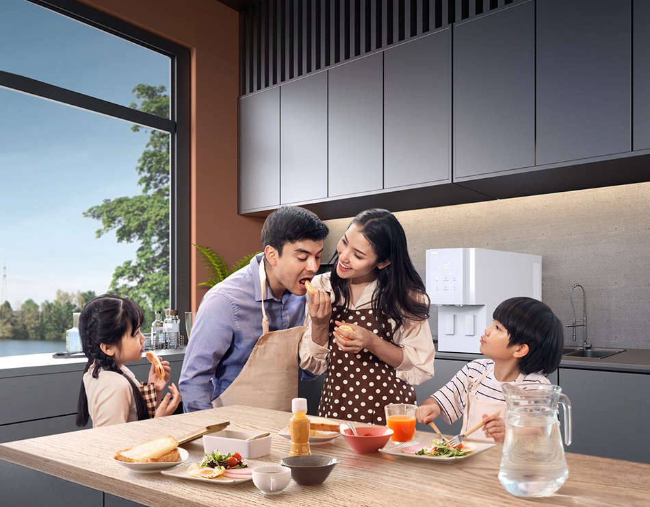 A family enjoying clean water in their kitchen with a Coway water purifier
